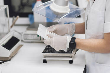 Mature female doctor holding medical equipment at laboratory - OCAF00489