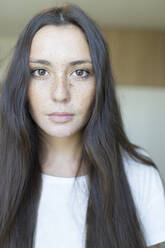 Close-up portrait of beautiful young woman with long brown hair at home - JPTF00504