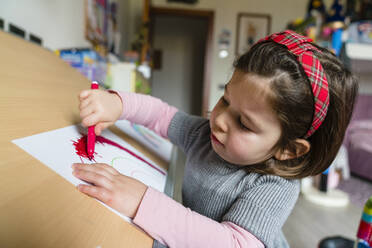 Nettes Vorschulmädchen, das zu Hause auf Papier zeichnet - MGIF00968