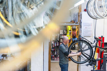 Bicycle mechanic working in bike shop - DIGF11581