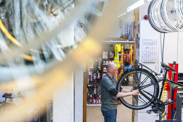 Fahrradmechaniker in einem Fahrradgeschäft - DIGF11581