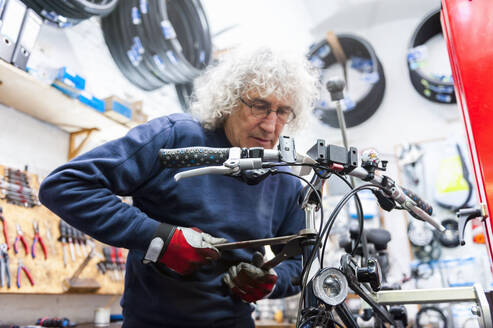 Fahrradmechaniker in einem Fahrradgeschäft - DIGF11593