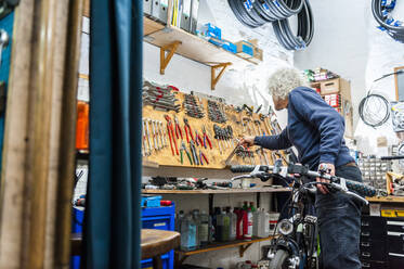 Fahrradmechaniker in einem Fahrradgeschäft - DIGF11595