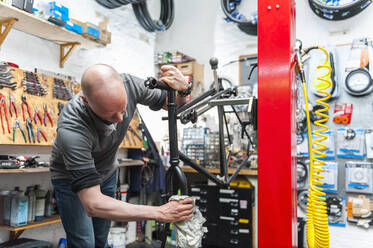 Bicycle mechanic working in bike shop - DIGF11597