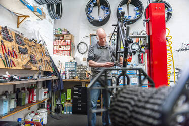 Bicycle mechanic working in bike shop - DIGF11600