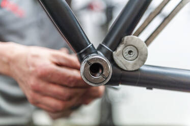 Fahrradmechaniker bei der Arbeit am Innenlager eines Fahrrads - DIGF11602