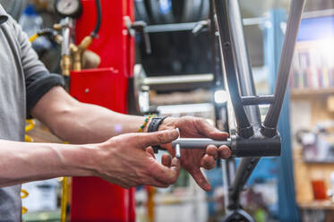 Fahrradmechaniker bei der Arbeit am Innenlager eines Fahrrads - DIGF11603