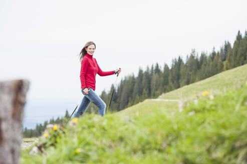 Smiling woman with hiking poles, Wallberg, Bavaria, Germany - DIGF11679