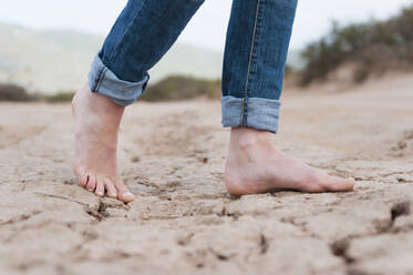 Woman's feet on dry soil, Sardinia, Italy - DIGF11697