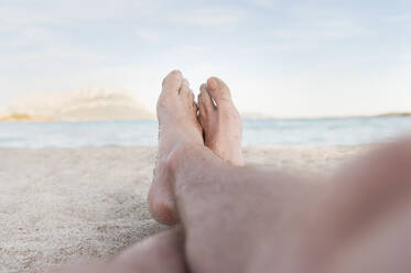 Sandige Füße eines Mannes am Strand, Sardinien, Italien - DIGF11712