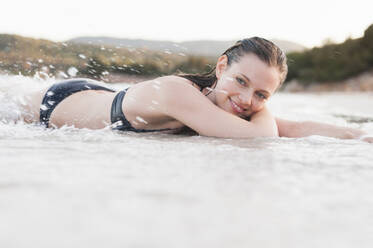 Porträt einer glücklichen Frau im Bikini, die sich am Meer entspannt, Sardinien, Italien - DIGF11718