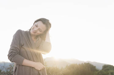 Portrait of smiling woman at backlight, Sardinia, Italy - DIGF11769