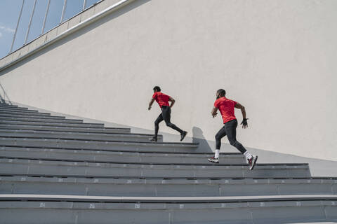 Sportler mit Gesichtsmasken beim Treppensteigen, lizenzfreies Stockfoto