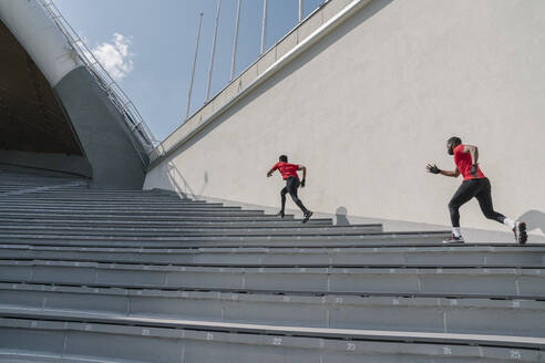 Sportler mit Gesichtsmasken beim Treppensteigen - AHSF02635
