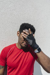 Portrait of sportsman wearing smartwatch and gloves - AHSF02646