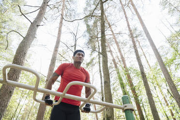 Sportler beim Üben am Klettergerüst im Wald - AHSF02656