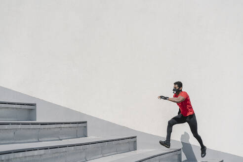 Sportler mit Gesichtsmaske läuft eine Treppe hinauf - AHSF02688