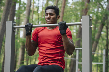 Sportler beim Training am Reck im Wald - AHSF02699