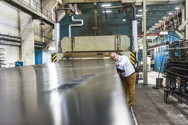 Ein leitender Angestellter einer Kautschuk verarbeitenden Fabrik prüft das Produkt - DIGF11824