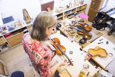 Geigenbauerin bei der Arbeit in ihrer Werkstatt - DIGF11888