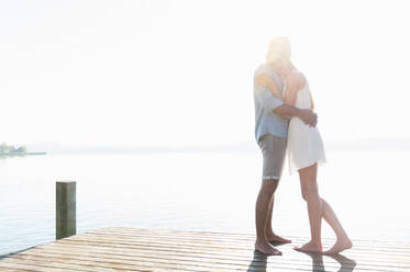 Happy young couple hugging each other on jetty - DIGF11926