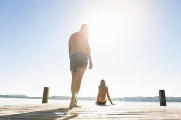 Young couple in swimwear on jetty - DIGF11968