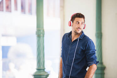 Portrait of young man listening music with headphones - DIGF12001