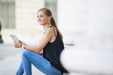 Portrait of smiling woman with digital tablet in the city - DIGF12066