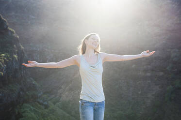 Wanderin mit erhobenen Armen im Sonnenlicht, Teneriffa, Balearische Inseln, Spanien - DIGF12124