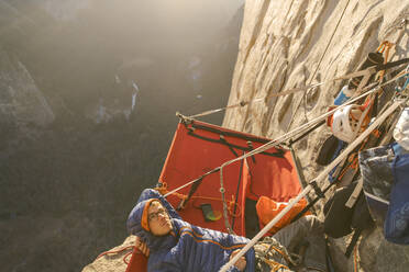 Kletterer, der bei Sonnenuntergang auf dem Portaledge liegt und zum The Nose Capitan hinaufschaut - CAVF82178