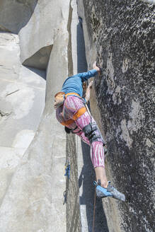 Bergsteiger schaut auf seine Füße in rosa Leggings auf der Nose im Yosemite - CAVF82192