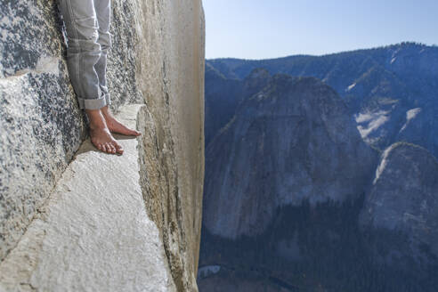 Man standing on a ledge, view of bare foot, very high El Capitan - CAVF82214