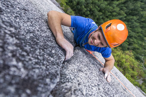 Kletterer schaut nach oben und lacht beim Klettern mit Helm Chief - CAVF82302