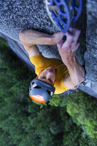 Mann platziert große Nocken in einem nicht ganz so breiten Granitriss beim Klettern in Squamish - CAVF82321