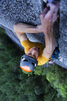 Mann platziert große Nocken in einem nicht ganz so breiten Granitriss beim Klettern in Squamish - CAVF82323
