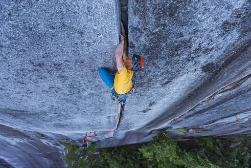 Mann klettert in Squamish, Kanada, BC, im Vorstieg aus breitem Granit - CAVF82324