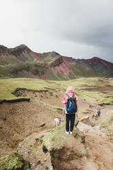 Eine junge Frau mit einem Rucksack steht auf einem Hügel in Peru - CAVF82406