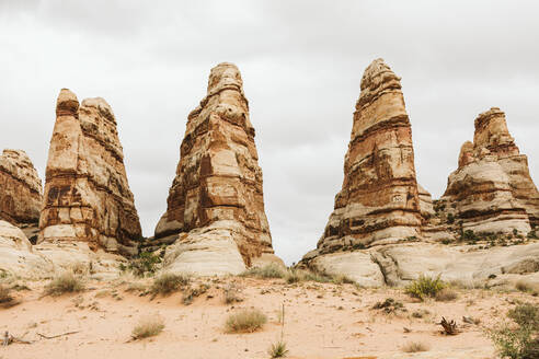 Four sandstone towers against gray skies in the desert of utah - CAVF82453