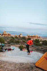 Weiblicher Camper beugt sich vor dem Schlafengehen in der Wüste von Utah zurück - CAVF82480