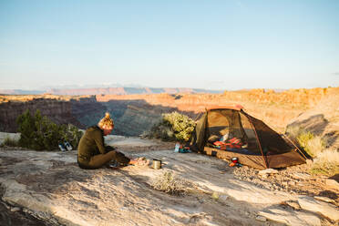 Camperin bereitet Essen neben dem Campingplatz mit Blick auf den Grand Canyon zu - CAVF82506