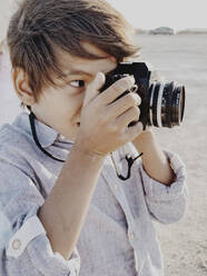 Close up portrait of a child taking a photo with a vintage camera - CAVF82527