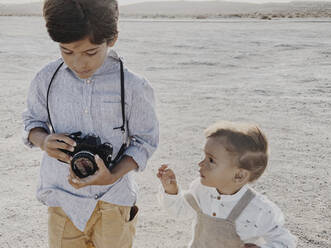 A kid holds a camera and a younger kid stands next to me - CAVF82531