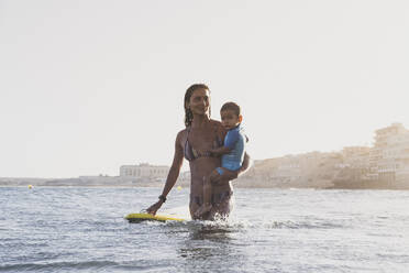 Ganzansichtiges Porträt von Mutter und Sohn auf dem Meer - CAVF82539