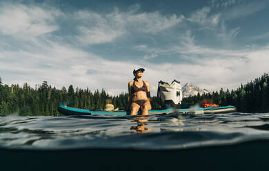A young woman enjoys a standup paddle board on Lost Lake in Oregon. - CAVF82564
