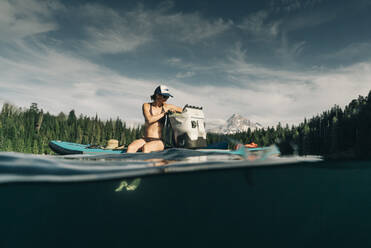 A young woman enjoys a standup paddle board on Lost Lake in Oregon. - CAVF82565