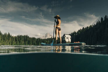 A young woman enjoys a standup paddle board on Lost Lake in Oregon. - CAVF82570