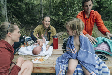 Eine Familie an einem Picknicktisch nach dem Schwimmen im Lost Lake, OR. - CAVF82581