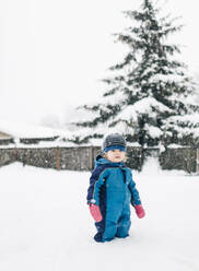 Ein Porträt eines jungen Mädchens im Schnee in ihrem Garten. - CAVF82582