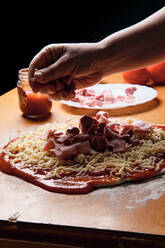 Bei der Zubereitung des Pizzabodens zu Hause legen wir Tomaten, Käse,... - CAVF82597