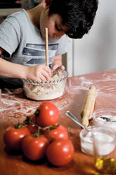 Child preparing pizza dough to make at home - CAVF82601